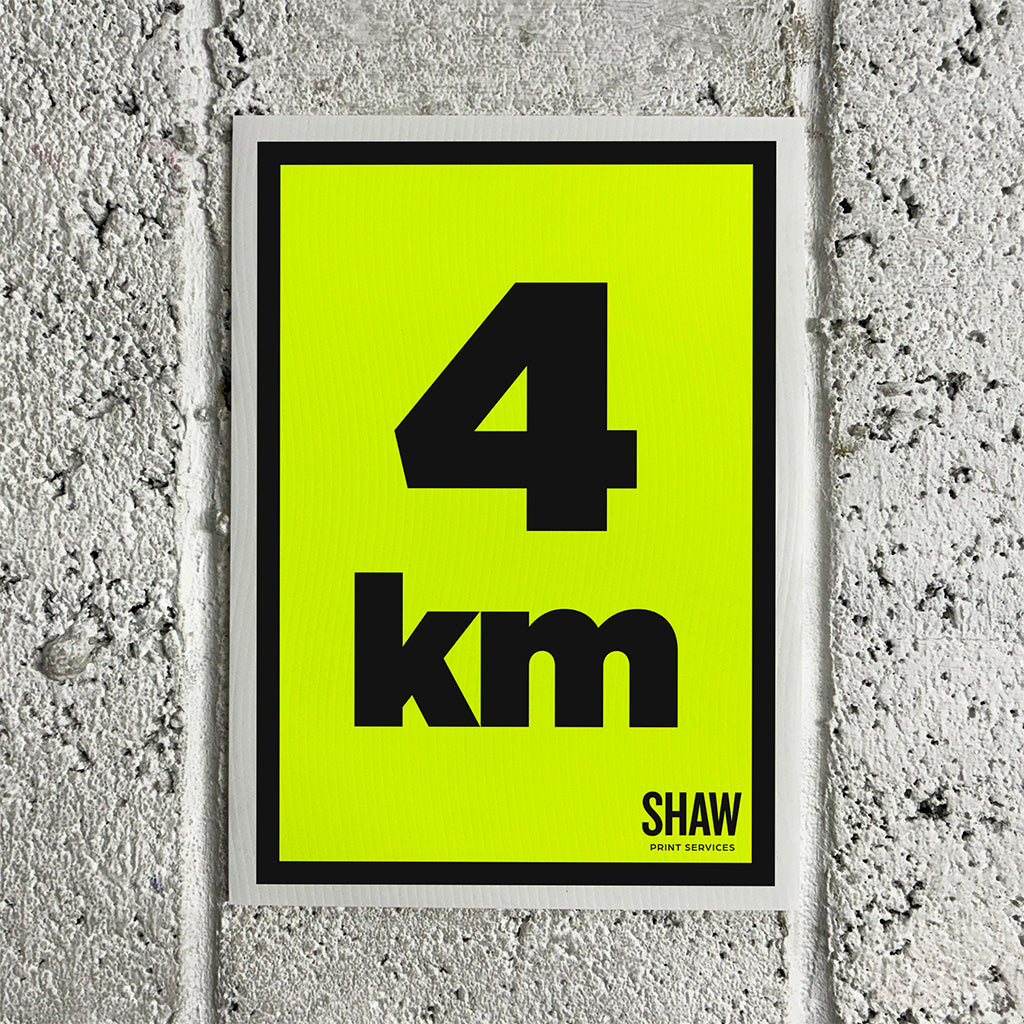 A 4KM distance marker sign on a yellow background with black text.