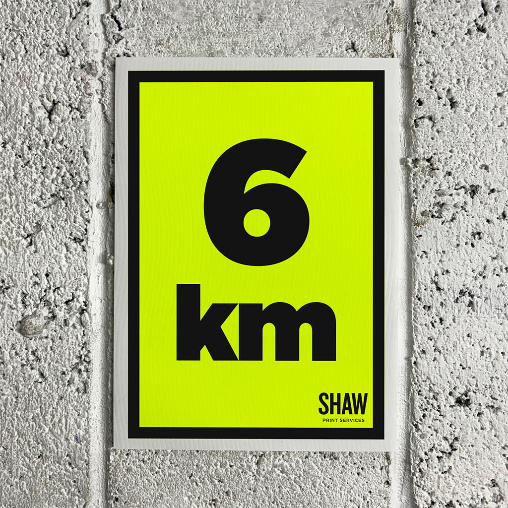 A 6KM distance marker sign on a yellow background with black text.