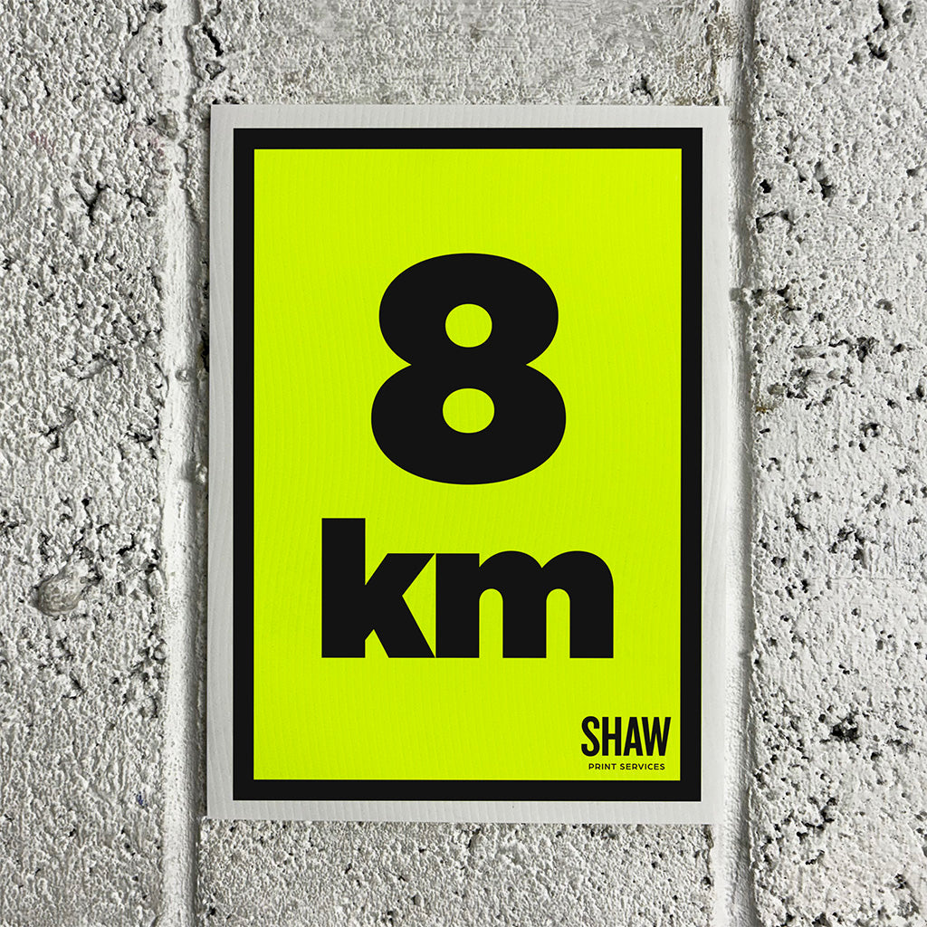 A 8KM distance marker sign on a yellow background with black text.