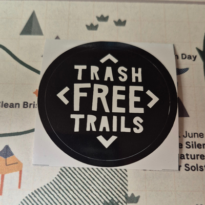 Round sticker with 'Trash Free Trails' text on a white background