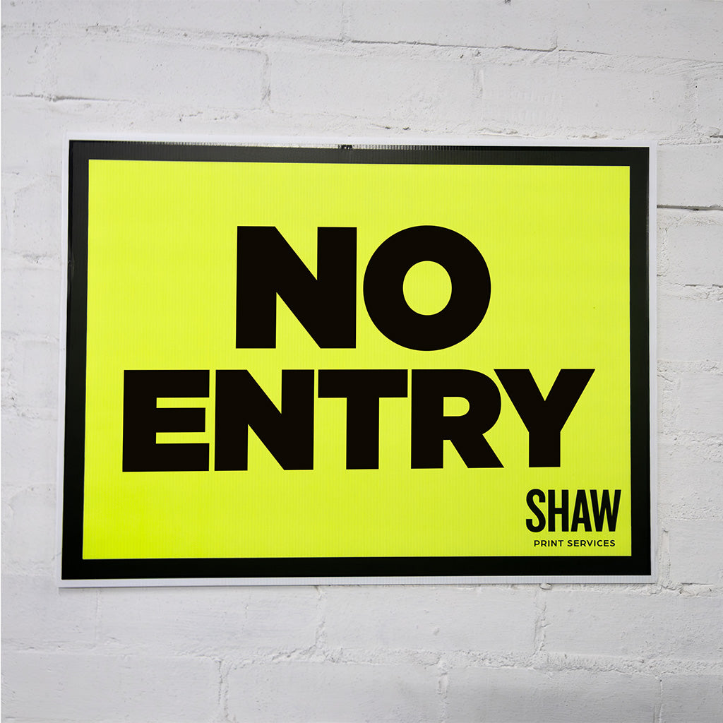 No Entry Sign with black writing on a grey brick background