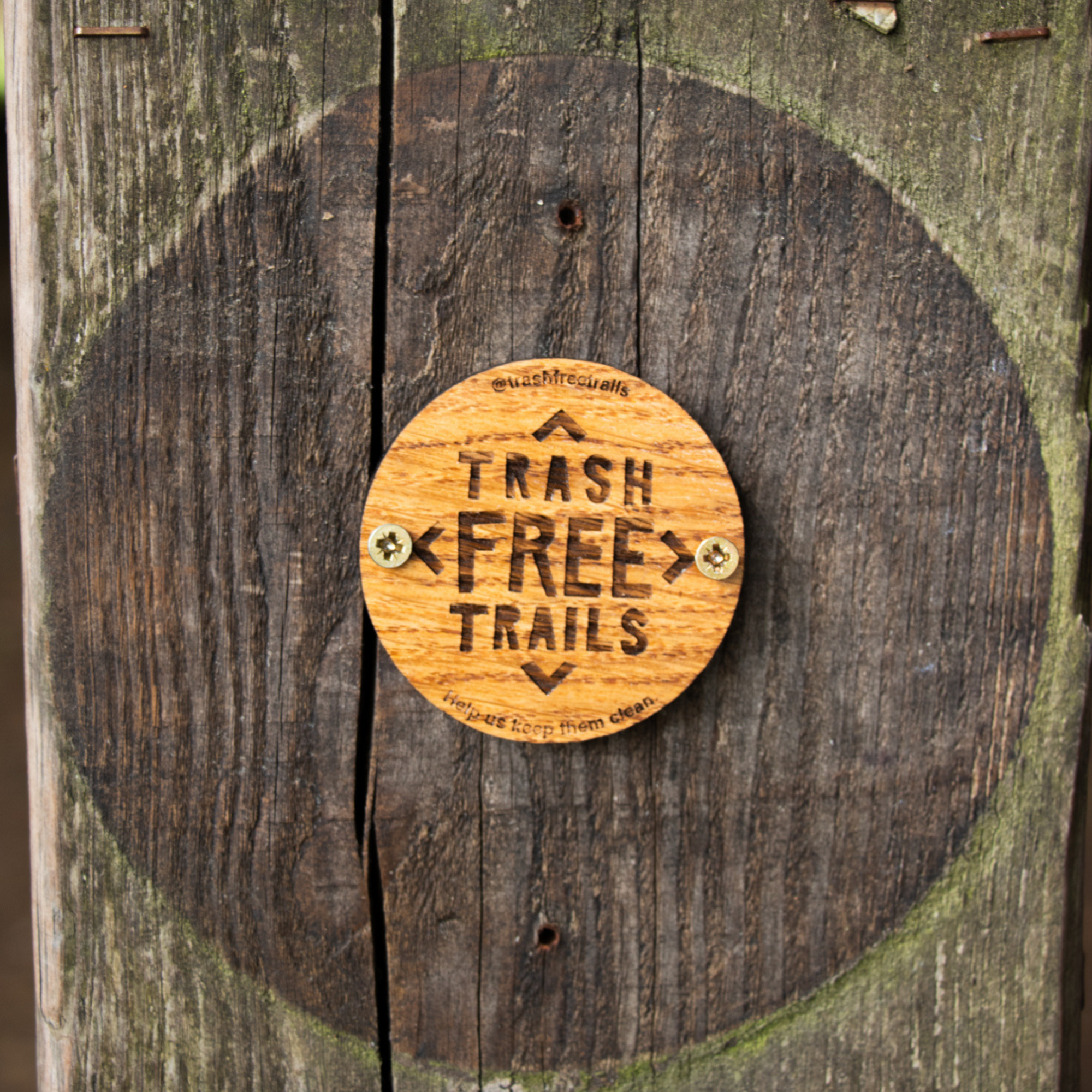 Wooden 'Trash Free Trails' sign on a wooden background