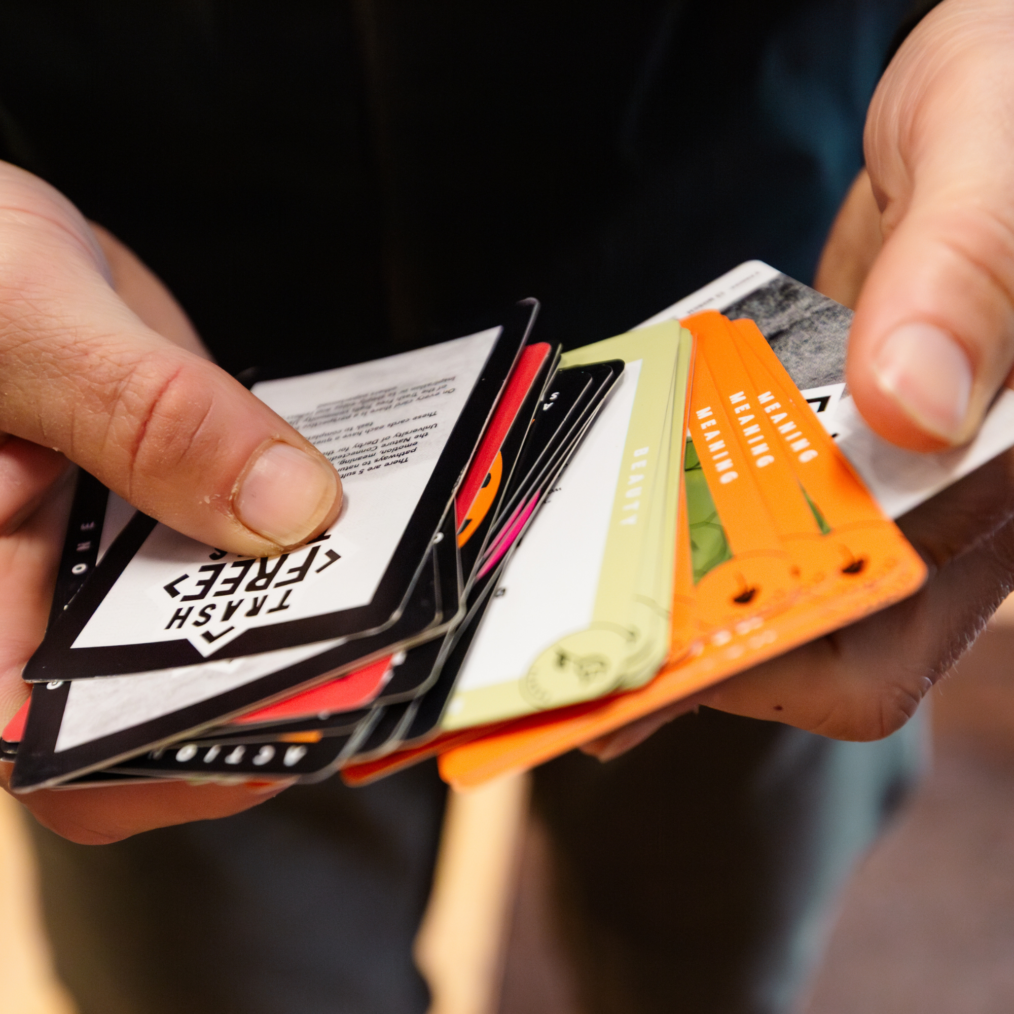 Person holding a deck of cards with various designs and text.