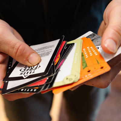Person holding a deck of cards with various designs and text.