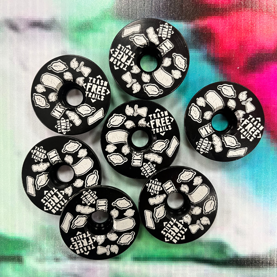 Seven Black and White Trash Free Trails Stem Caps.