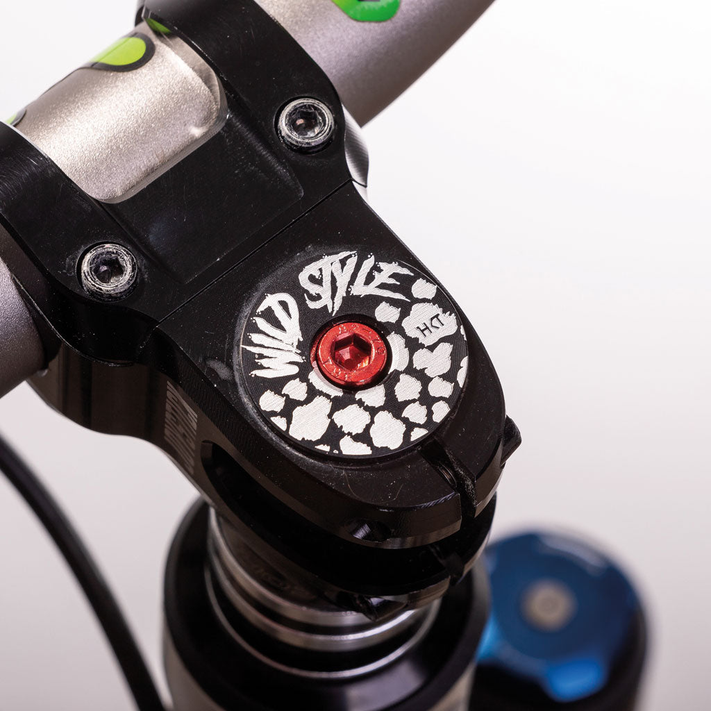 Wild Style Text black stem cap with red bolt.